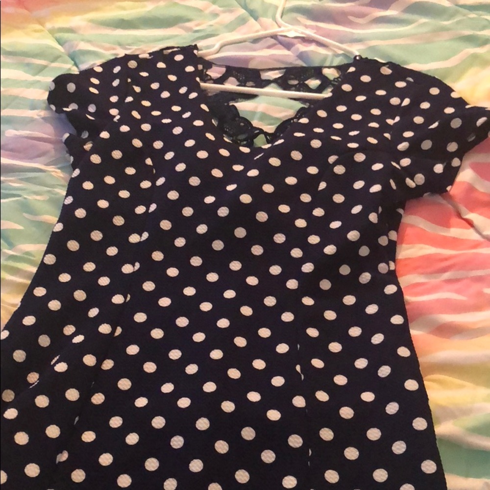 A navy polka dot dress with designs on the back.